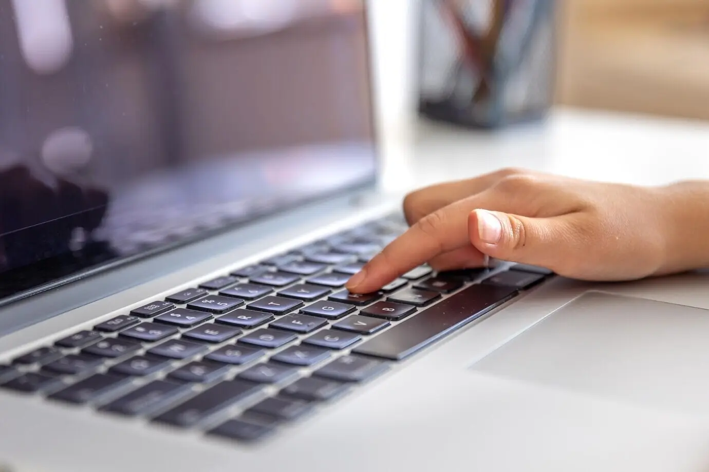 Девушка печатает на клавиатуре ноутбука. Руки девушки на клавиатуре.