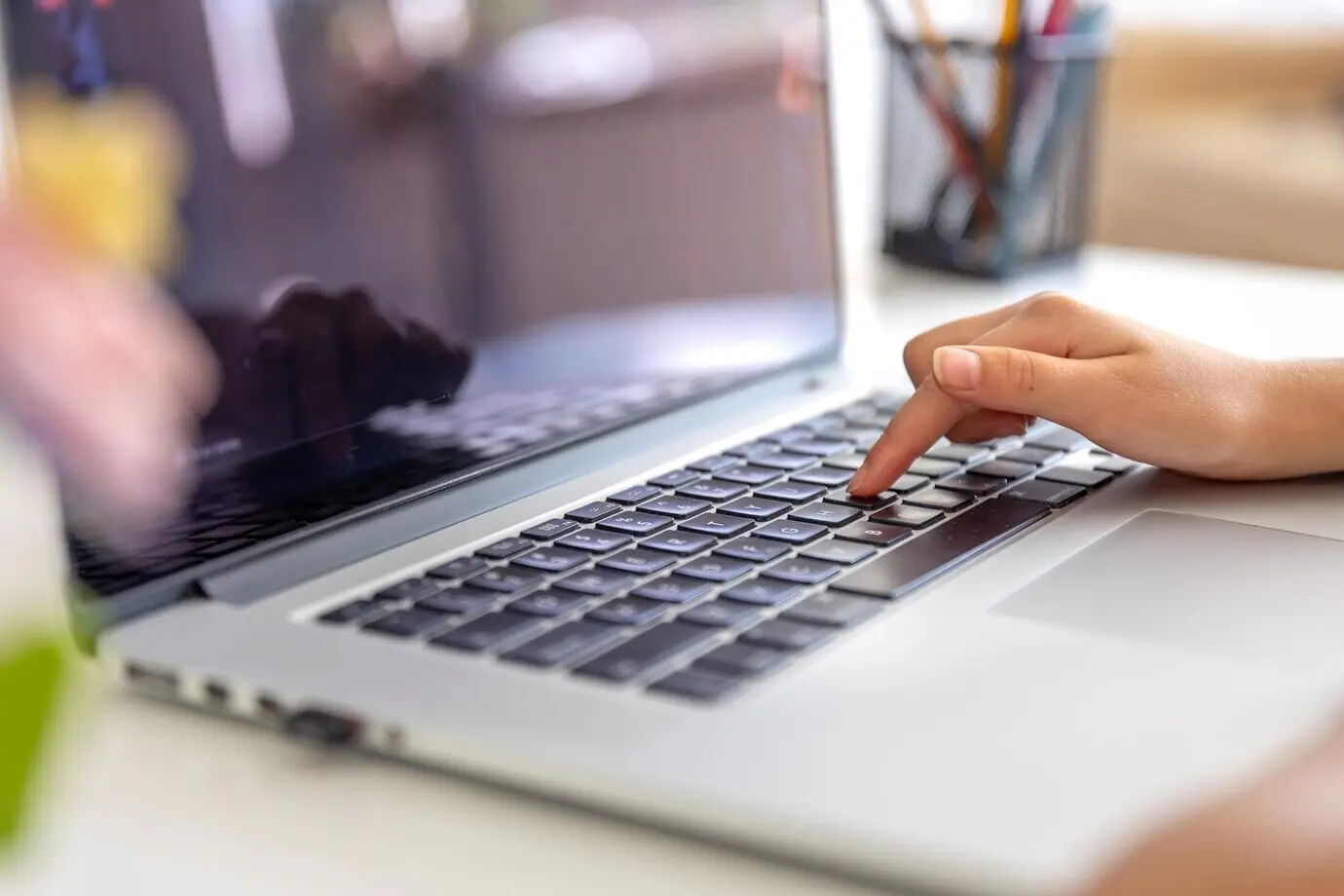 Девушка набирает текст на клавиатуре ноутбука. Руки девушки на клавиатуре.